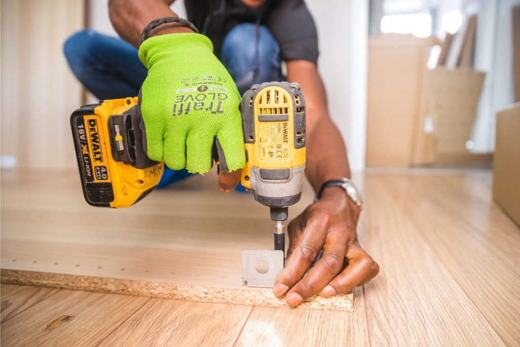 Man drilling fixing to wooden furniture